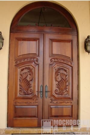 Массивная арочная дверь с резьбой и фрамугой